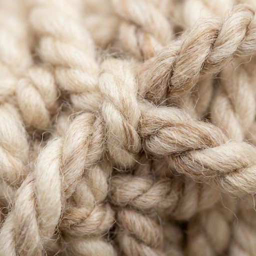 Close-up macro photography of high-quality wool rug fibers and hand-knotted yarn